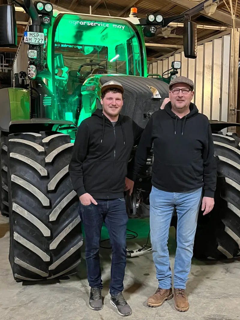Cornelius May und Georg May vor einem Fendt in der Halle