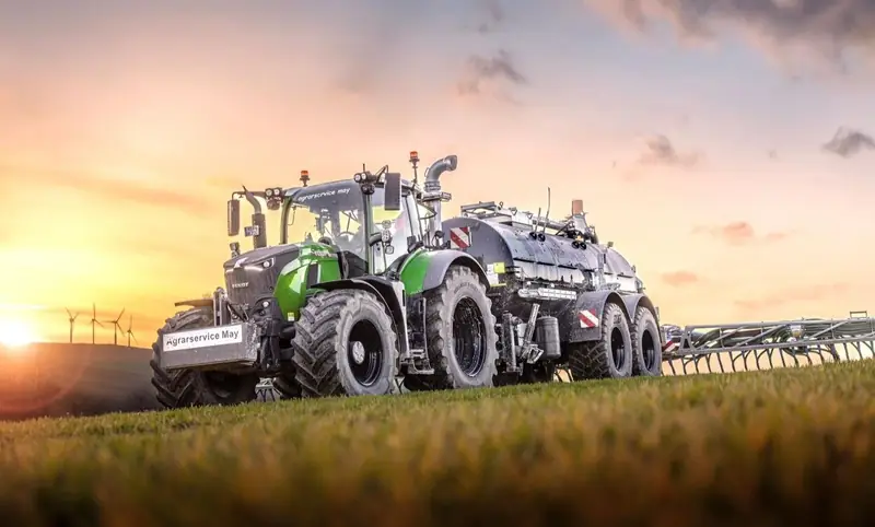 Fendt mit Güllefass auf dem Feld bei Sonnenuntergang
