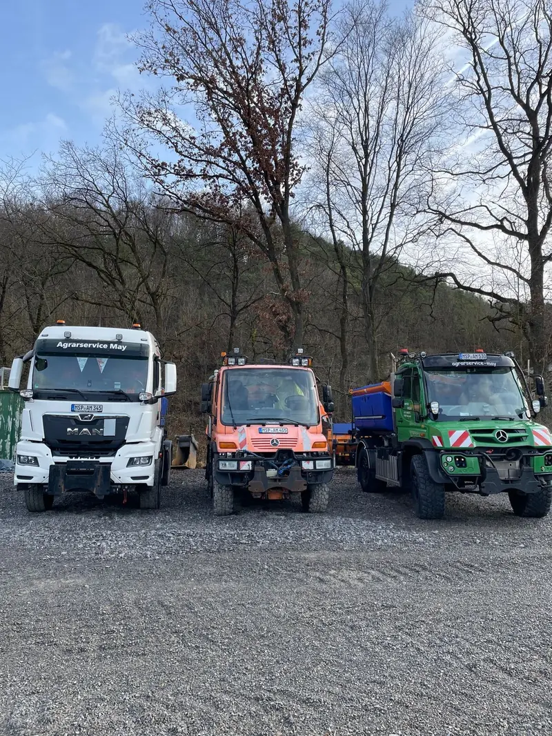 Drei Winterdienstfahrzeuge von Agrarservice May auf dem Hof